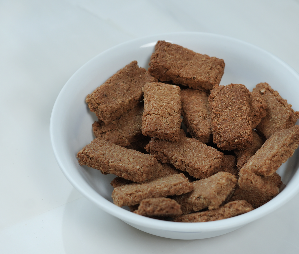 White bowl filled with healthy Laghumi coconut snack bite – light, natural and satisfying snack made with real coconut on a white background